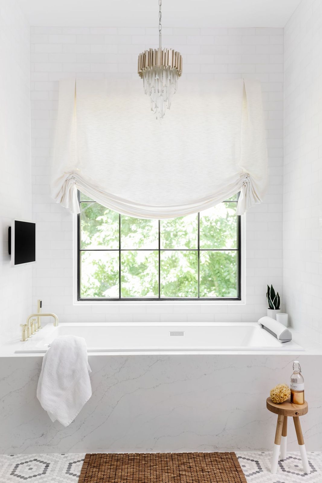 Highgate estate primary bath — freestanding tub in front of a steel-framed casement window, capiz-shell chandelier, and marble surround