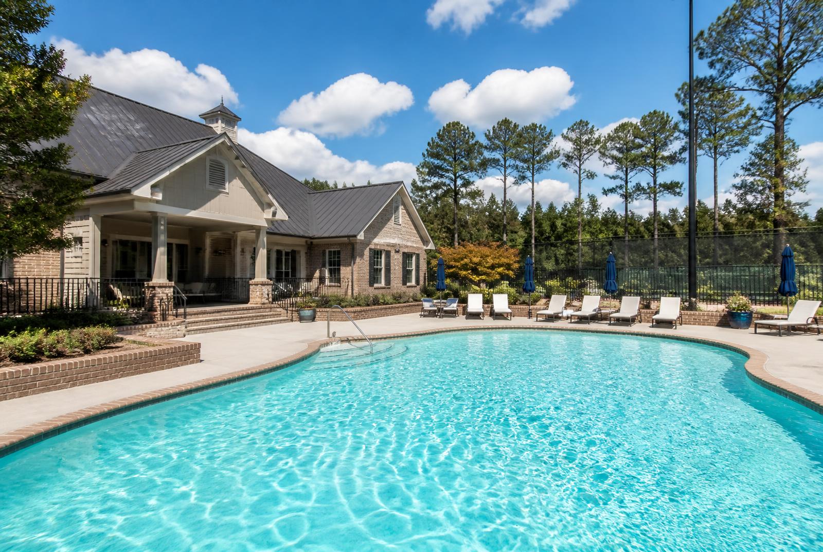 Highgate estate approach — landscaped brick driveway, stone entry piers, and mature hardwood canopy along the Providence Road corridor