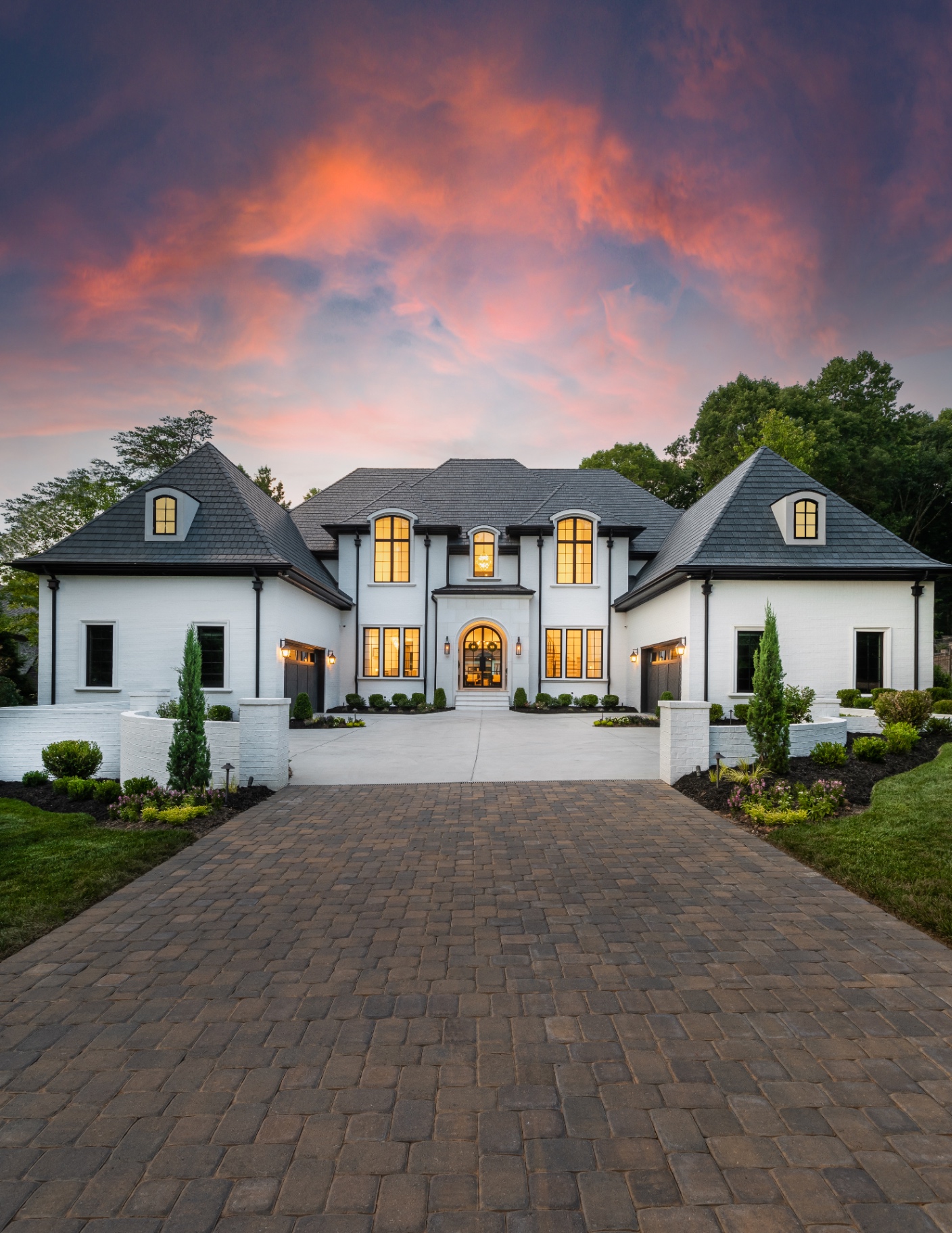Highgate estate approach — landscaped brick driveway, stone entry piers, and mature hardwood canopy along the Providence Road corridor