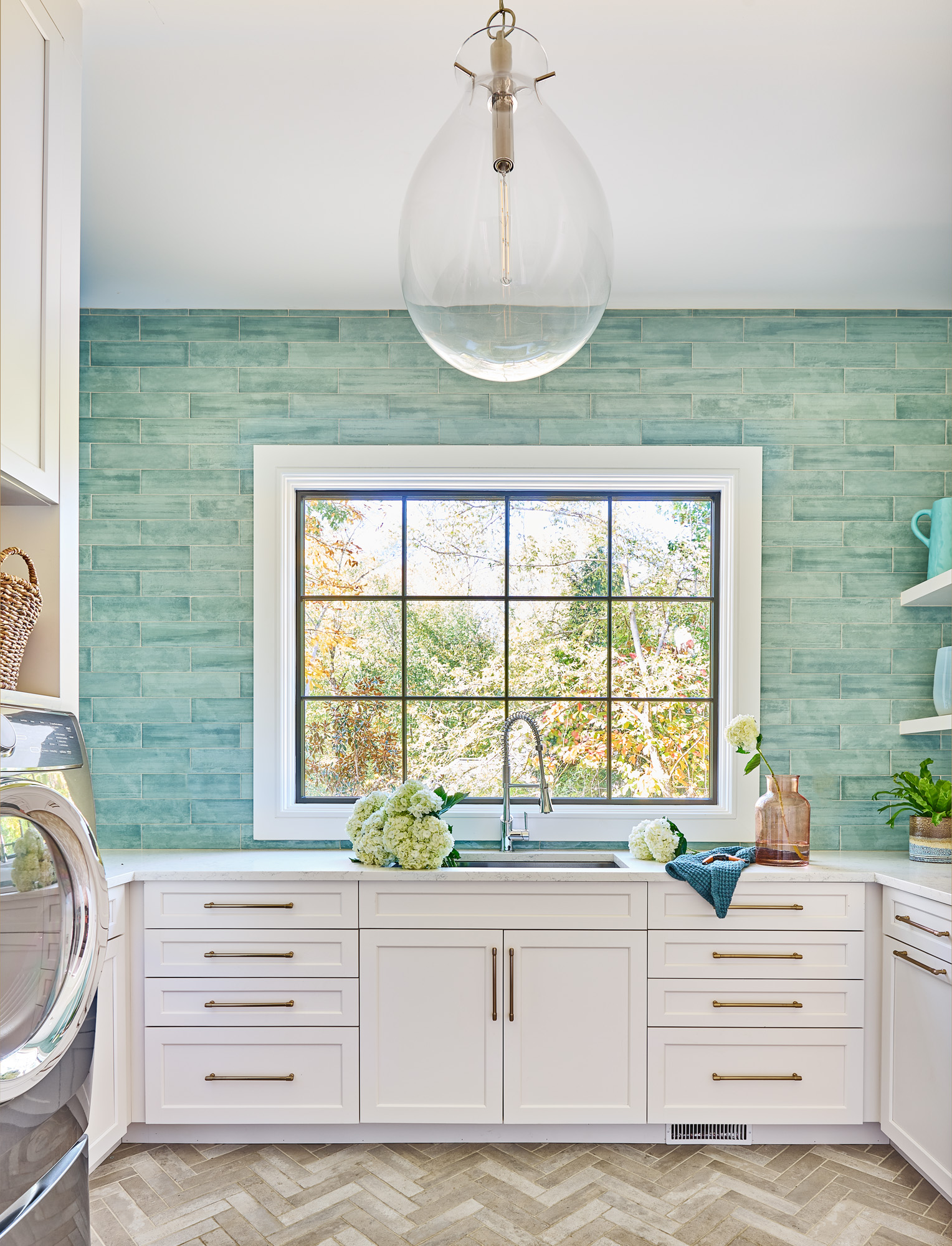 Highgate estate laundry room with teal glazed subway tile, herringbone brick floor, and integrated lighting — one of many spaces served by whole-home technology